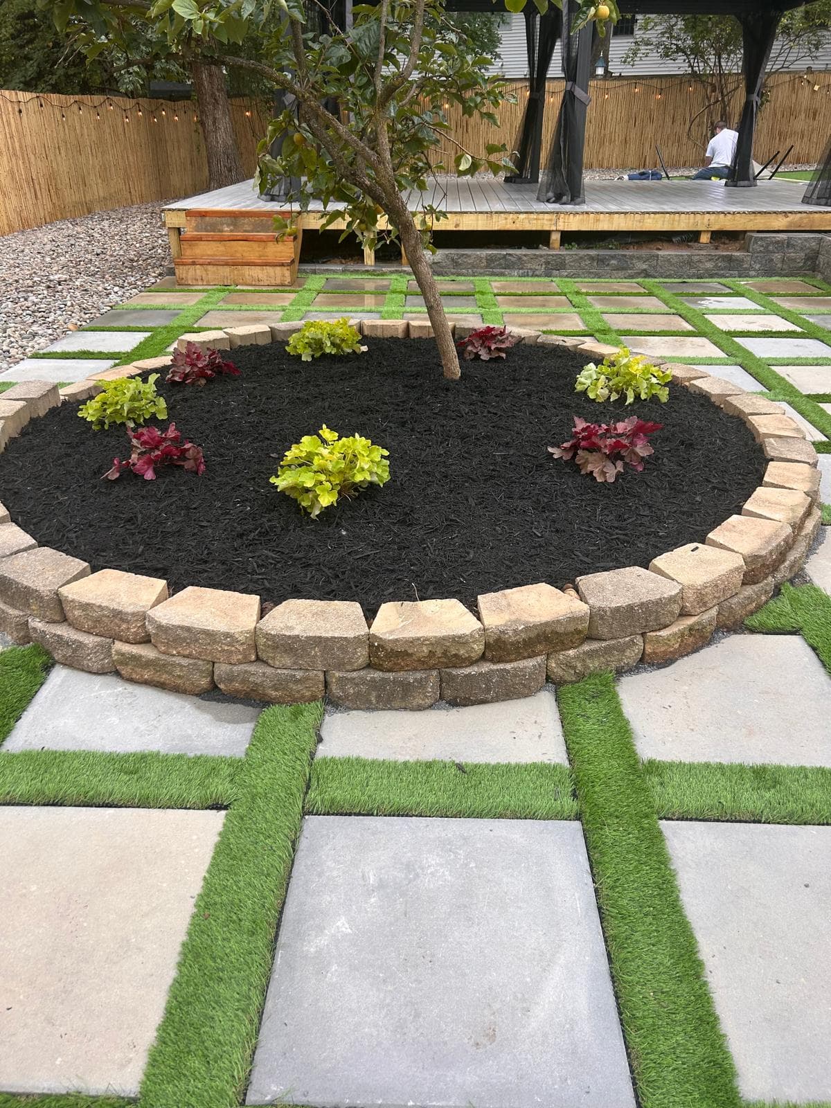 Tree ring planting bed with fresh mulch and stone border
