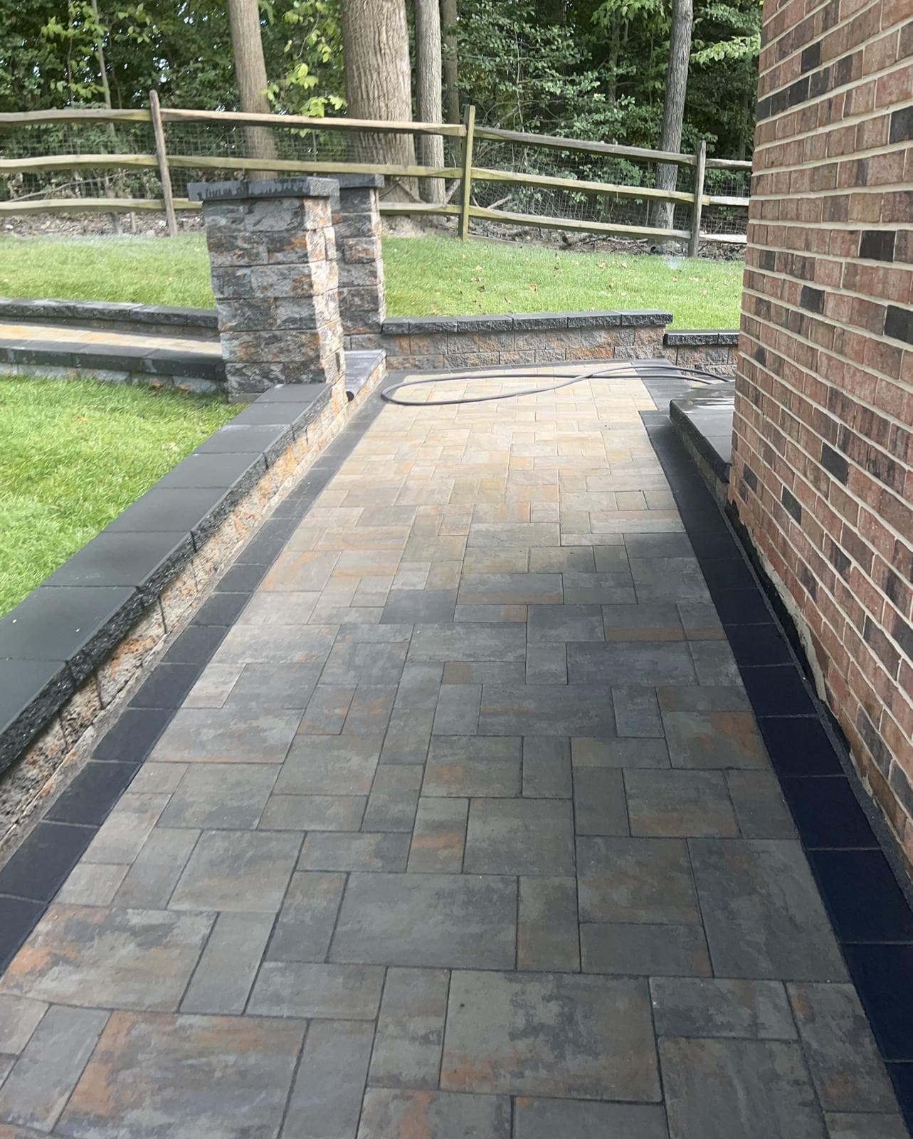 Paver walkway alongside a brick house