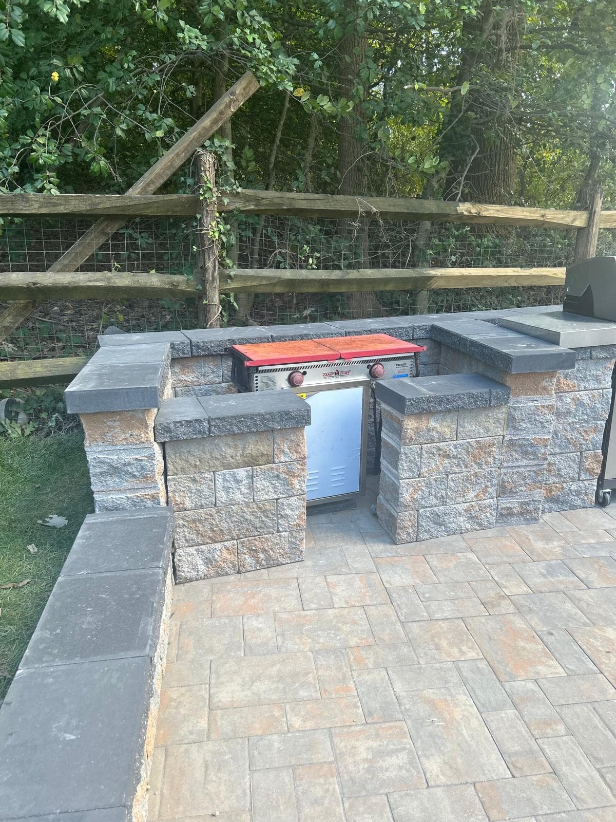 Outdoor kitchen with grill and stainless steel storage cabinet