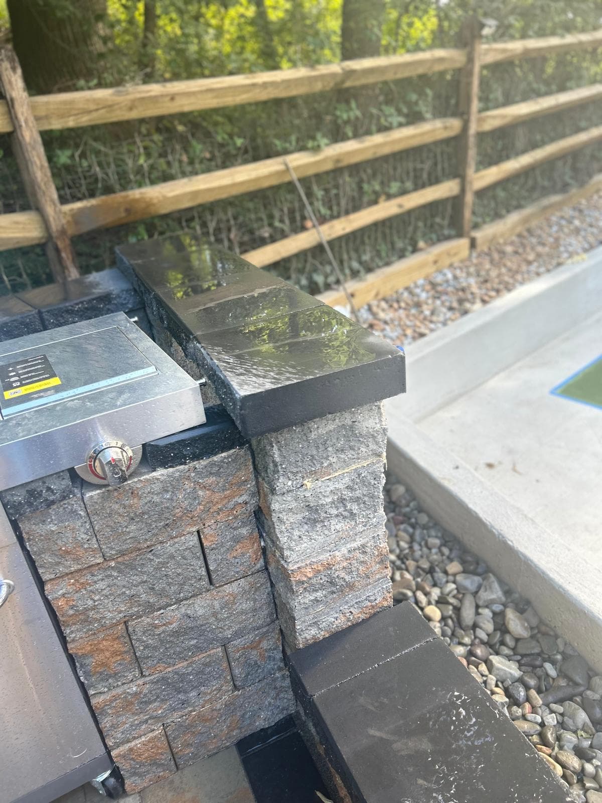 Stone column with grill and river rocks