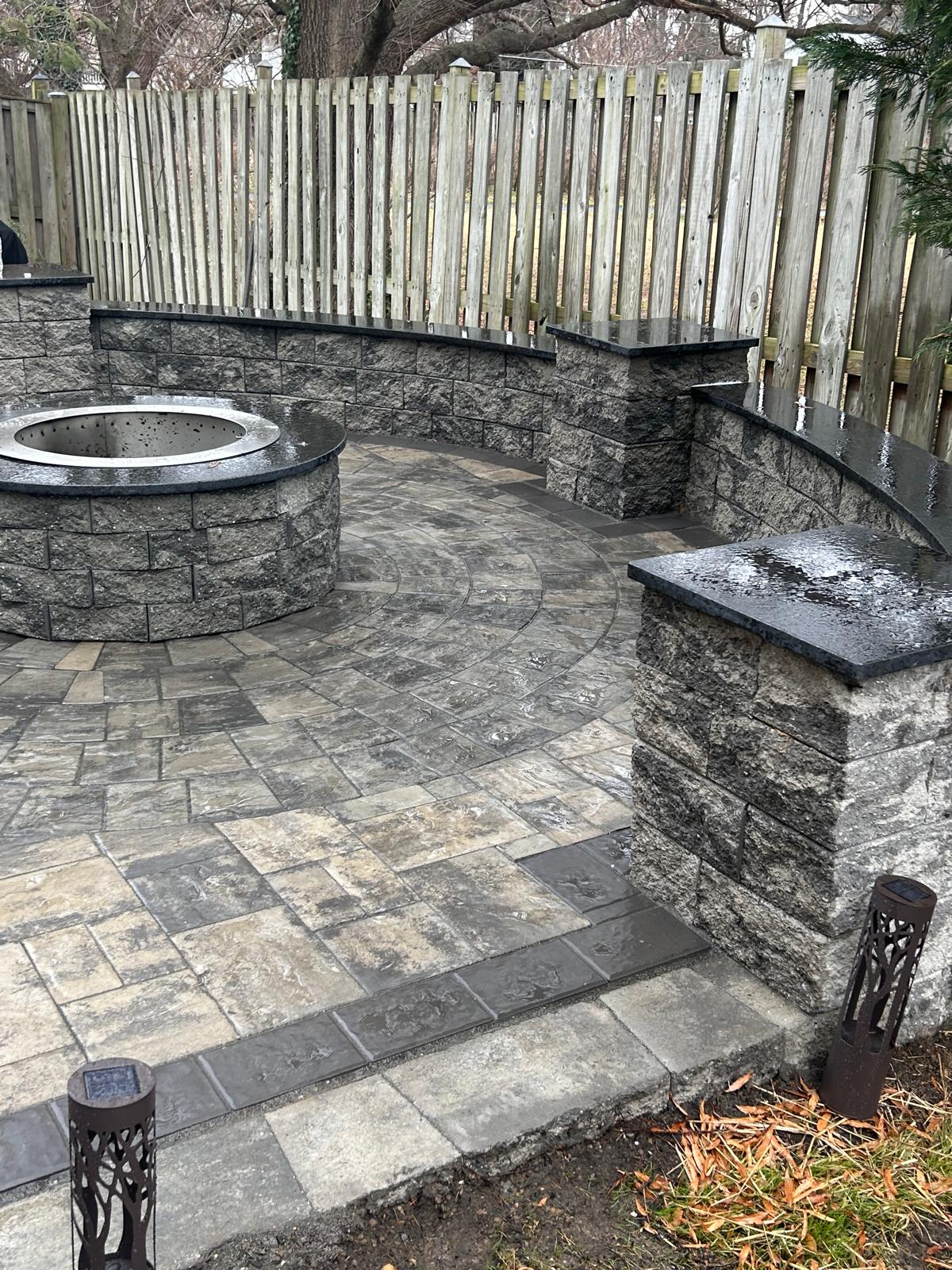 Fire pit and curved seat wall on a dormant winter property by Kaeler